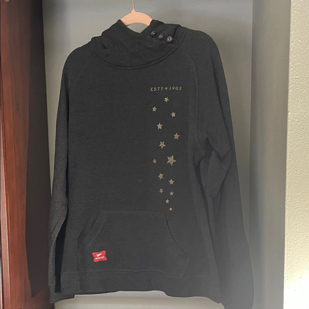 Dark gray miller high life hoodie with button details around neck.